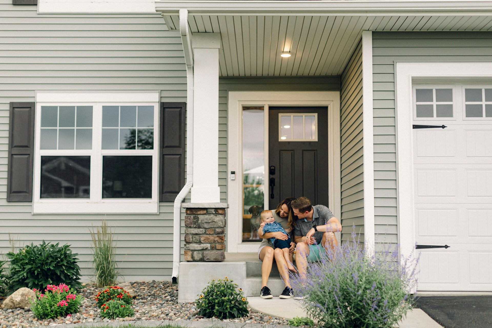 Family seated at the front porch of a home